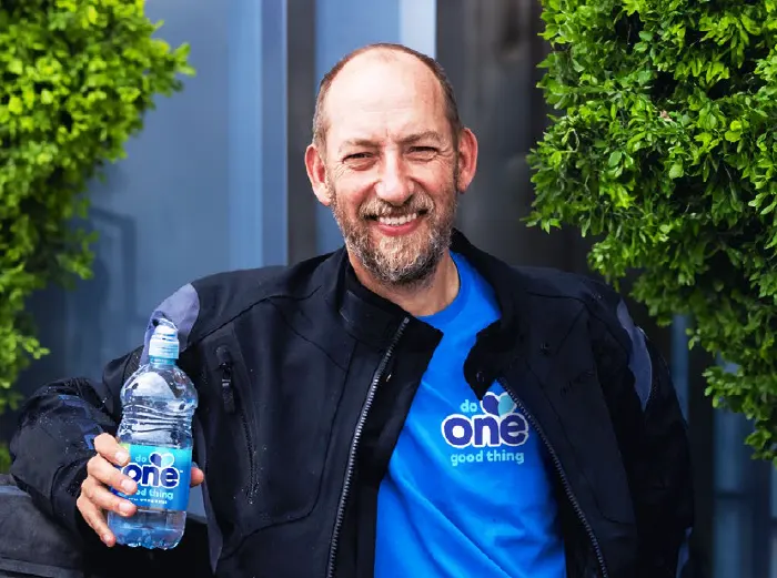 Founder of One Water, Duncan Goose, holding a bottle of One Water